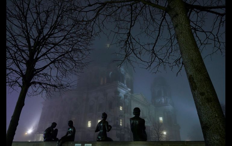 La Catedral de Berlín se observa bajo un manto de niebla junto a estatuas cerca del río Spree, en la capital alemana. EFE/H. Jeon