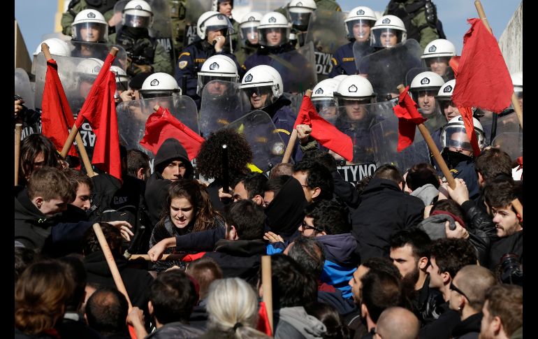 Policías se enfrentan con manifestantes afuera del parlamento en Atenas, Grecia, durante un acto en contra de una nueva legislación que limitará el derecho a ir a huelga. AP/T. Stavrakis