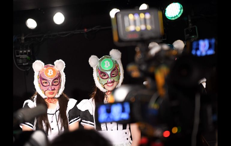Integrantes del grupo Kasotsuka Shojo (Chicas de moneda virtual) con máscaras de bitcoin se ven en una entrevistas tras una presentación en vivo en Tokio, Japón.  AFP/K. Nogi