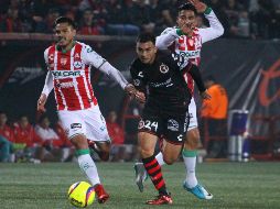 Luis Chávez (derecha), anotador del gol del partido, disputa el balón con Xavier Baez. EFE/A. Zepeda