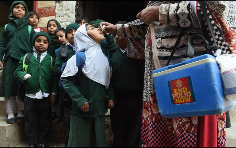 Una trabajadora del sector salud administra vacunas contra la poliomielitis a niños en Lahore, Pakistán. La transmisión de la enfermedad aún es endémica en el país. AFP/A. Ali