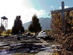 Personas buscan entre los restos del templo Santa Juana en la comuna de Cunco, región de la Araucanía.
