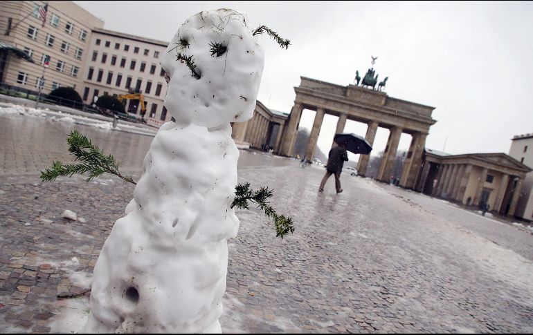 Un mono de nieve se ve frente a la Puerta de Brandenburgo en Berlín, Alemania. AFP/DPA/W. Kumm