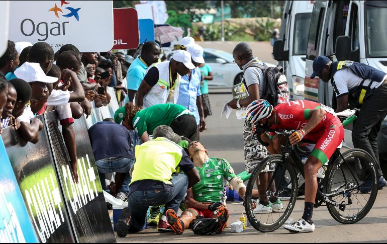 Un ciclista lesionado recibe ayuda tras un accidente en la segunda etapa de la competencia La Tropicale realizada en Fougamou, Gabón. AFP/S. Jordan