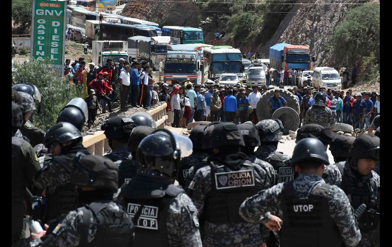 Policías intentan desbloquear una avenida en Cochabamba, Bolivia, donde se cumple un paro ciudadano para exigir al Gobierno la abrogación del código penal. EFE/J. Abrego