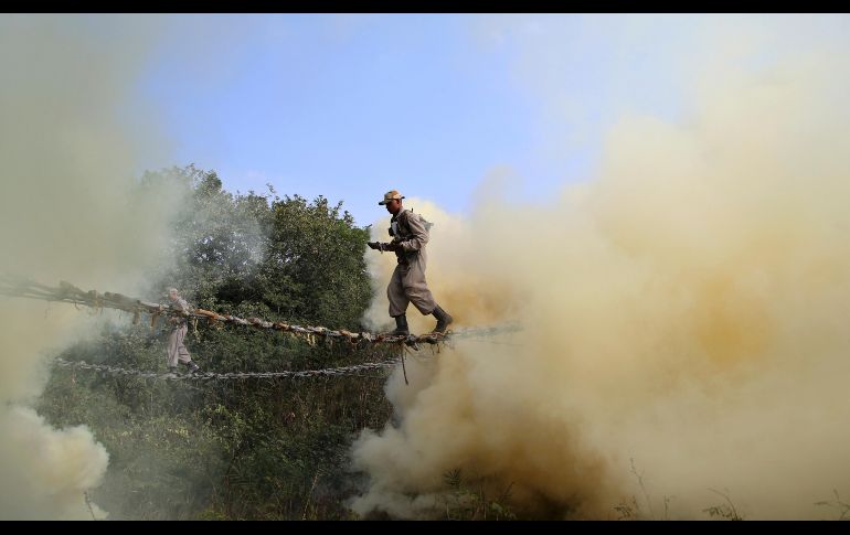 Soldados cruzan por una cuerda entre humo que emana de latas, durante un entrenamiento en Bangalore, India. AP/A. Rahi