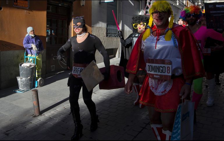 Un trabajador mira a competidores de una carrera de tacones en Madrid, España, organizada para promover el carnaval en Puerto de la Cruz. AP/P. White