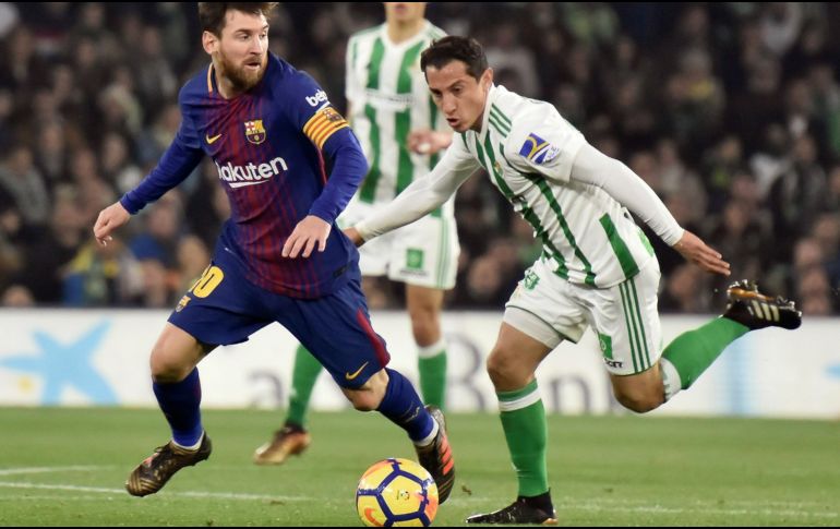Lionel Messi, del Barcelona, (I) y Andrés Guardado (D), del Betis, disputan un balón. EFE/ R. Caro