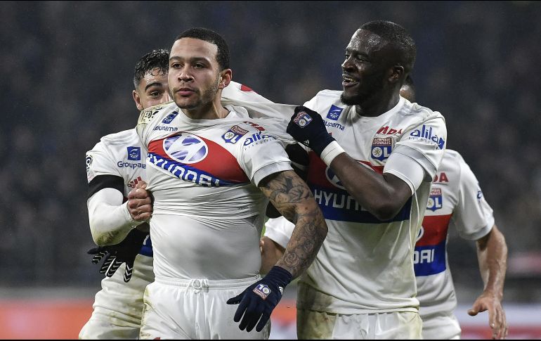 Memphis Depay (I) celebra el gol en tiempo de reposición que le da la victoria al Lyon. AFP/J. Pachoud