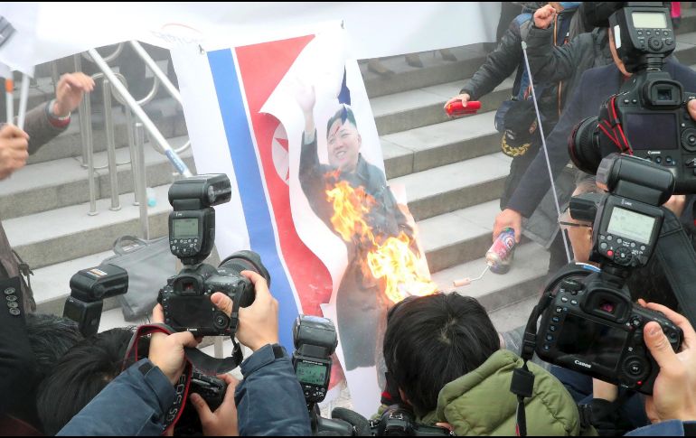 Manifestantes queman un retrato del líder norcoreano luego de leer un comunicado de repudio. AFP/D. Ilbo