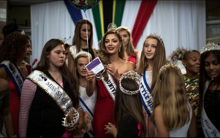 Demi-Leigh Nel-Peters (c), Miss Universo 2017, se rodea de jóvenes ganadoras de concursos de belleza en el aeropuerto de Johanesburgo, Sudáfrica, en su primera visita a casa tras ganar la corona. AFP/G. Khan
