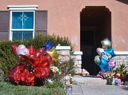 Fuera de la casa, se han dejado flores, globos, entre otros objetos, como una muestra de afecto por los menores. AFP/ F. Brown