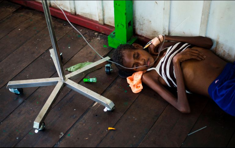 Una joven descansa en el piso de un hospital en Agats, en la provincia indonesia de Papua. Un brote reciente de sarampión y malnutrición en esta provincia ha afectado a unos 800 niños. AFP/B. Ismoyo