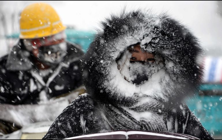 Una mujer se traslada en moto en Bozhou, en la región de Anhui. Se prevé la caída de entre 10 y 20 centímetros de nieve en zonas de las provincias de Anhui, Henan, Hubei, Hunan, Jiangsu, Jiangxi, Shanghai y Zhejiang.