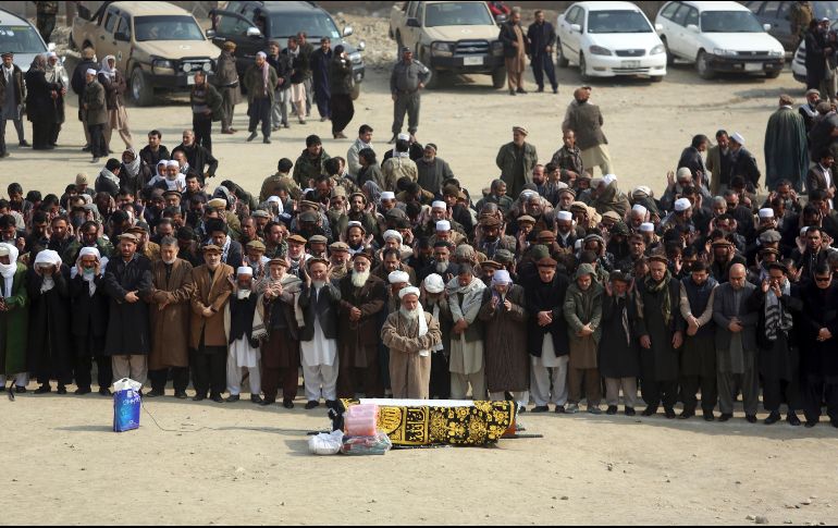 Varias personas rezan durante el funeral de una de las víctimas de la explosión. AP/R. Gul