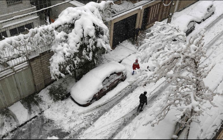 La región norte y oeste de Irán ha registrado fuertes nevadas desde el jueves. Habitantes caminan en la capital Teherán. AFP/A. Kenare