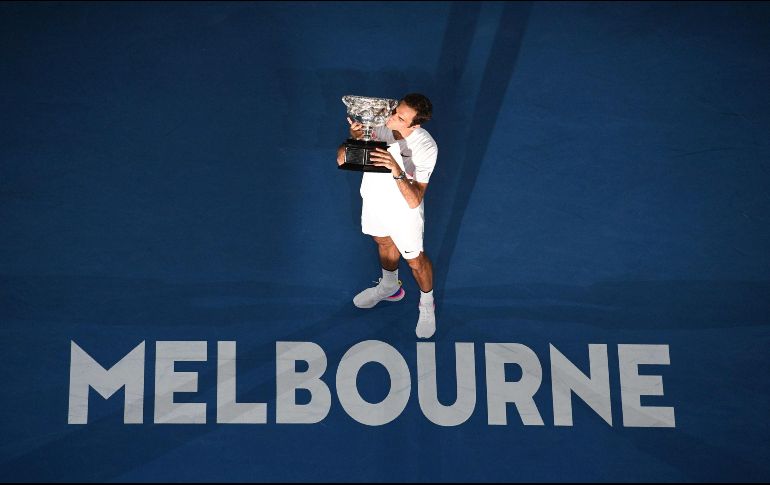 El suizo Roger Federer celebra con su trofeo tras vencer al croata Marin Cilic en la final del Abierto de Australia, en Melbourne. AFP/W. West
