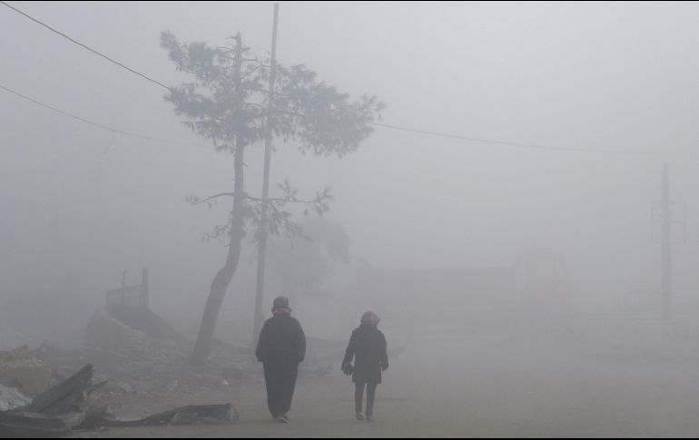 Habitantes caminan entre una densa niebla en Mudayra, Siria. AFP/A. Eassa