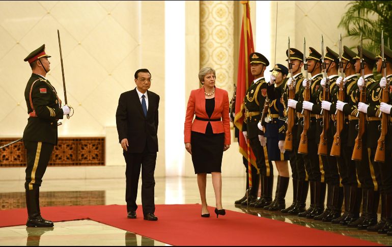 La primera ministra británica Theresa May revisa la guardia militar con su homólogo chino, Li Keqiang, en una ceremonia de bienvenida en el Gran Salón del Pueblo de Pekín. AFP/G. Baker