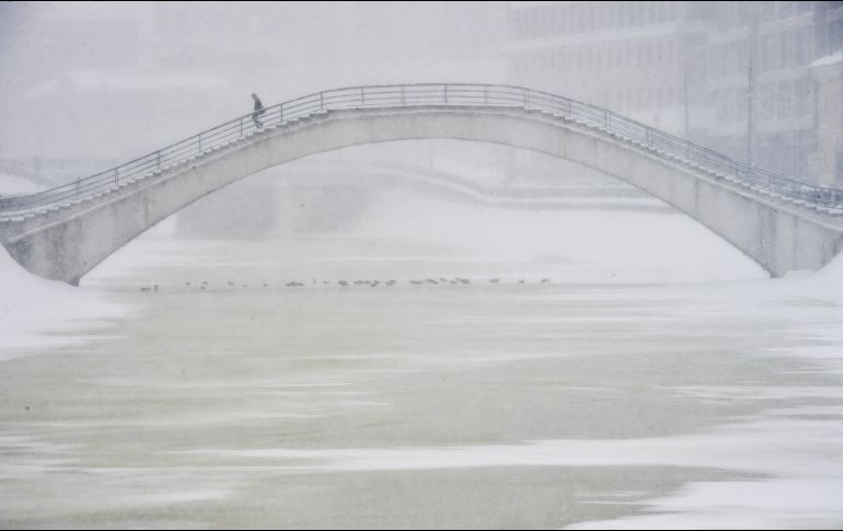 Un hombre cruza un puente durante una nevada en Moscú, Rusia. AFP/O. Maltseva