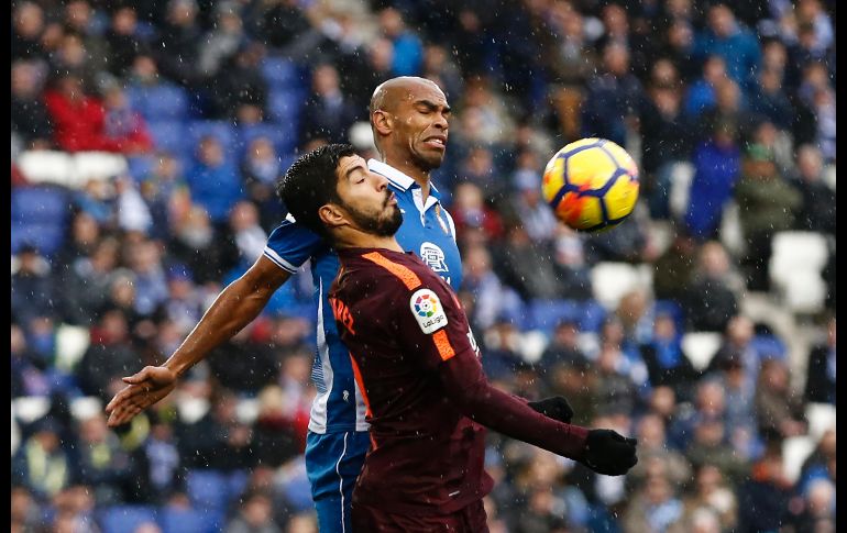 Luis Suárez (i), del Barcelona, y Naldo, del Espanyol, disputan un balón en partido de la Liga española disputado en Cornella de Llobregat. AFP/P. Barrena