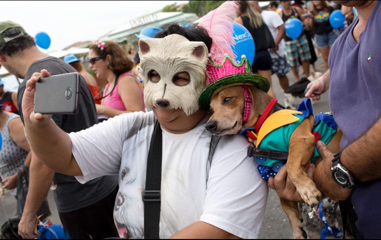 Una mujer toma una foto con su perro, ambos disfrazados para el desfile de perros del carnaval, realizado en la playa de Copacabana en Río de Janeiro, Brasil. AP/S. Izquierdo