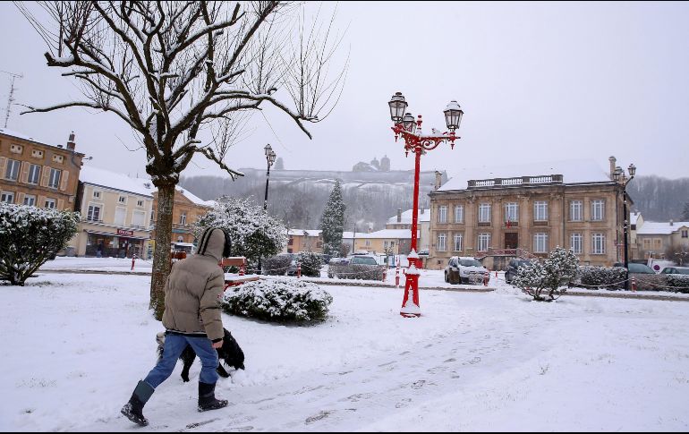 Un hombre camina por una plaza cubierta por la nieve en Montmedy, al norte de Francia. EFE/J. Warnand