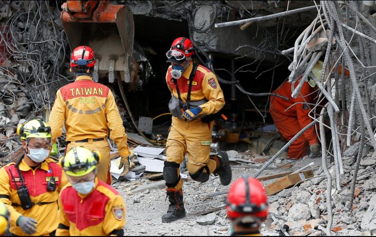 Varios miembros de los servicios de rescate salen de un edificio en ruinas. EFE/B. Tongo