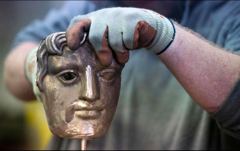 Un trabajador quita restos de una máscara para los premios BAFTA, durante una presentación para medios previo a la entrega de los premios británicos de cine del 18 de febrero. AFP/J. Tallis