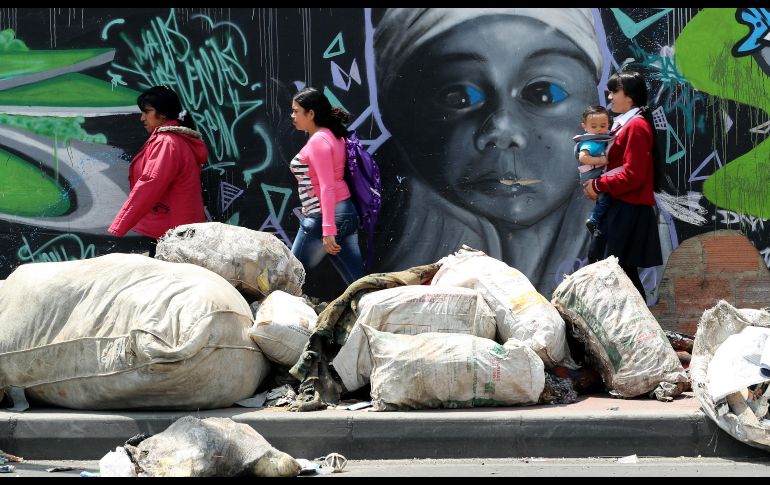 Peatones caminan en medio de la basura en Bogotá, Colombia. En las calles de la ciudadnse acumulan desechos desde hace una semana por la huelga de empleados de ese servicio. EFE/M. Dueñas