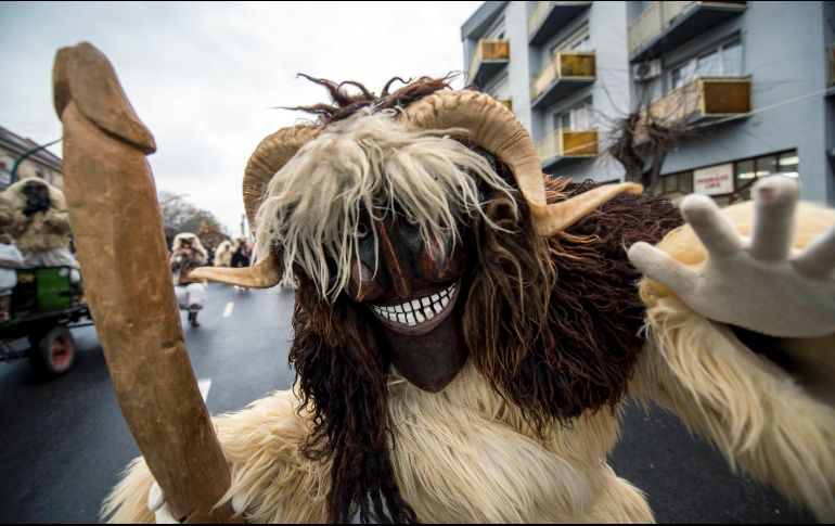 Un juerguista vestido de traje de piel de oveja con cuernos y máscara sostiene un falo de madera durante el tradicional Desfile del Carnaval de Busos en Mohacs, Hungría. EFE/T. Soki
