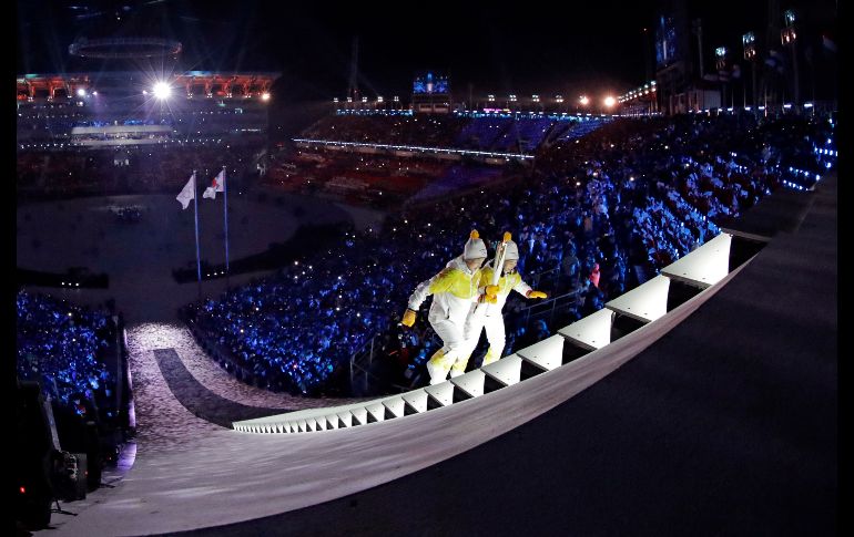 La norcoreana Jong Su Hyon (i) y la sudcoreana Park Jong-ah cargan la antorcha olímpica.
