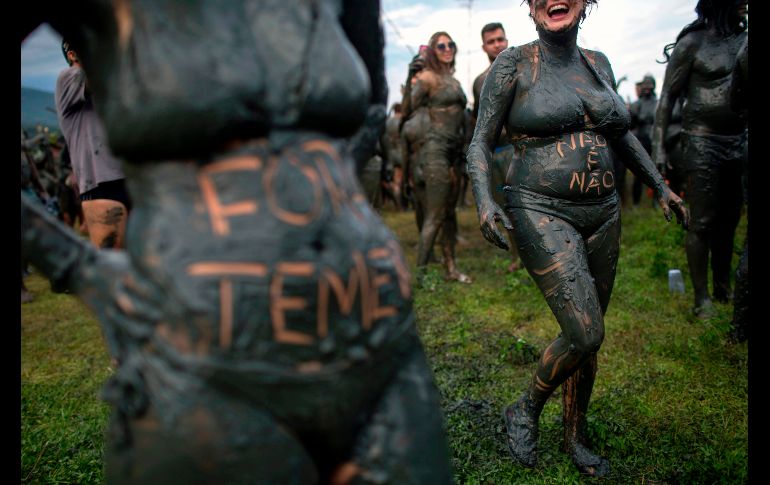 Diversos participantes aprovecharon el barro para escribir en sus cuerpos. AFP / M. Pimentel