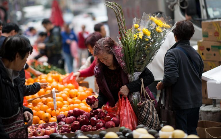 Una mujer compra manzanas en un mercado en Hong Kong durante los preparativos para el Año Nuevo chino. EFE/J. Favre