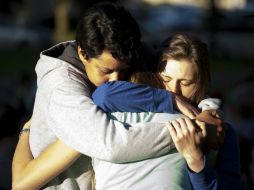 Tres jóvenes se abrazan después del tiroteo. EFE /
