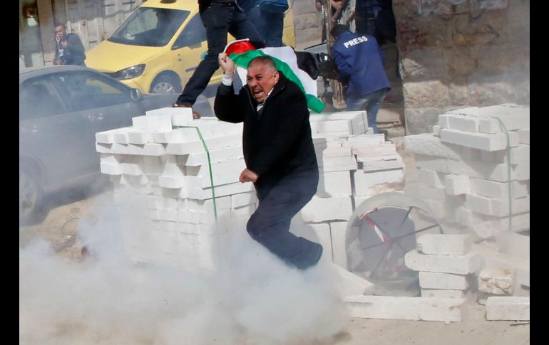 Un manifestante palestino reacciona a la detonación de una granada durante una protesta en la ciudad de Hebrón. AFP / H. Bader