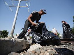 Migrantes y ciudadanos limpian las vías del tren