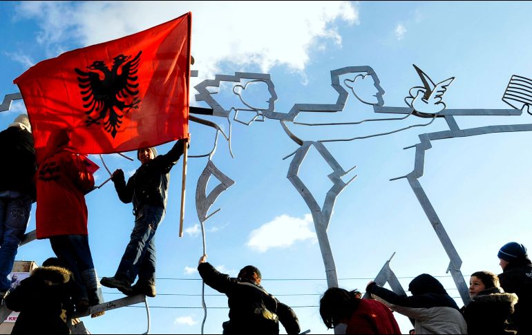 Niños albaneses de Kosovo se suben a una estatua mientras la gente celebra su independencia. AP/B. Szandelszky
