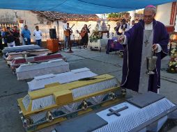 Un sacerdote bendice los ataúdes de las víctimas del accidente. AP/L. Cruz