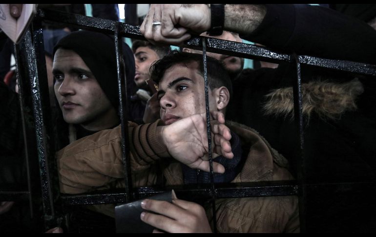 Palestinos aguardan permiso para cruzar desde Rafha, en la Franja de Gaza, hacia Egipto, tras la reapertura del puesto fronterizo por parte del gobierno egipcio. AFP/S. Khatib