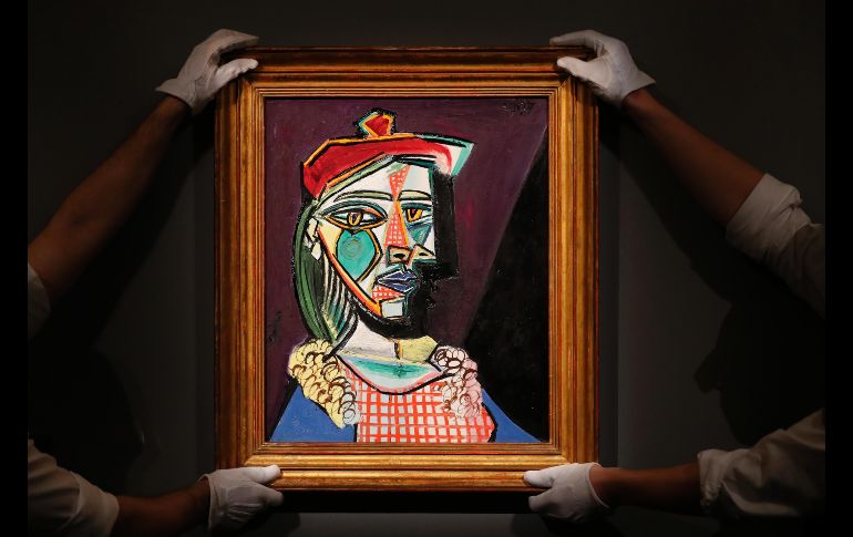 Trabajadores de Sotheby's en Londres sostienen una obra de Pablo Picasso, 