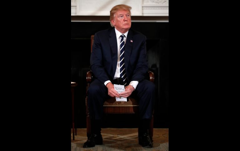 El presidente Donald Trump tomó las notas en sus manos mientras escuchaba testimonios en la Casa Blanca.