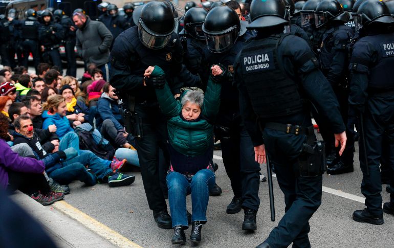 Agentes de los Mossos d'Esquadra desalojan a personas del Tribunal Superior de Justicia de Cataluña en Barcelona, España, en una protesta por las actuaciones de la justicia en la crisis catalana. AFP/P. Barrena