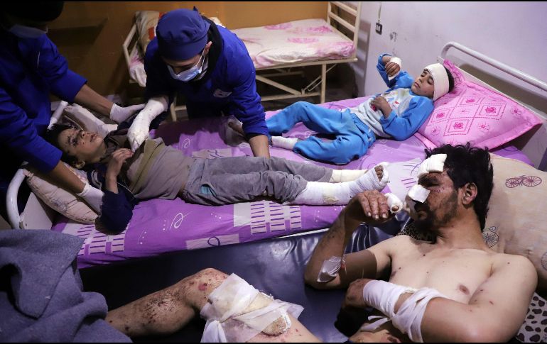 Médicos atienden a Omar, de 10 años, en un hospital junto a su padre y hermana. La familia resultó herida en un ataque aéreo en el enclave rebelde de Otaybah, Siria. AFP/A. Almohibany