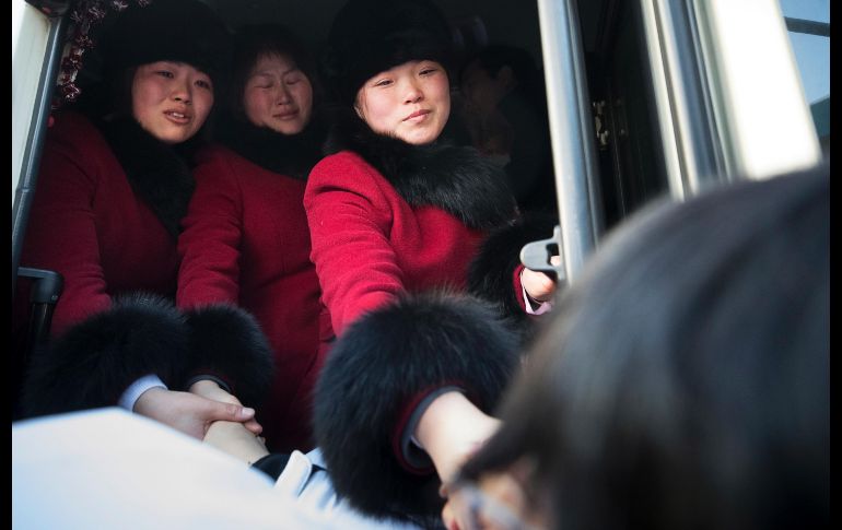 Jugadores de hockey de Corea del Norte en un camión se despiden de sus compañeras de Corea del Sur, en su partida de la Villa Olímpica en la ciudad surcoreana de Gangneung. AP/Yonhap/D. Yun