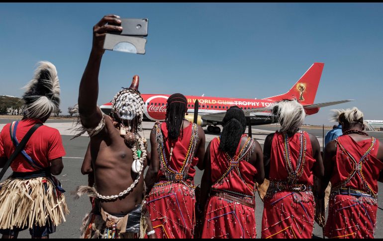 Un danzante se toma una foto en el aeropuerto de Nairobi, Kenia, a la llegada del avión que transporta el trofeo de la Copa del Mundo de la FIFA, como parte de un tour mundial. AFP/Y. Chiba
