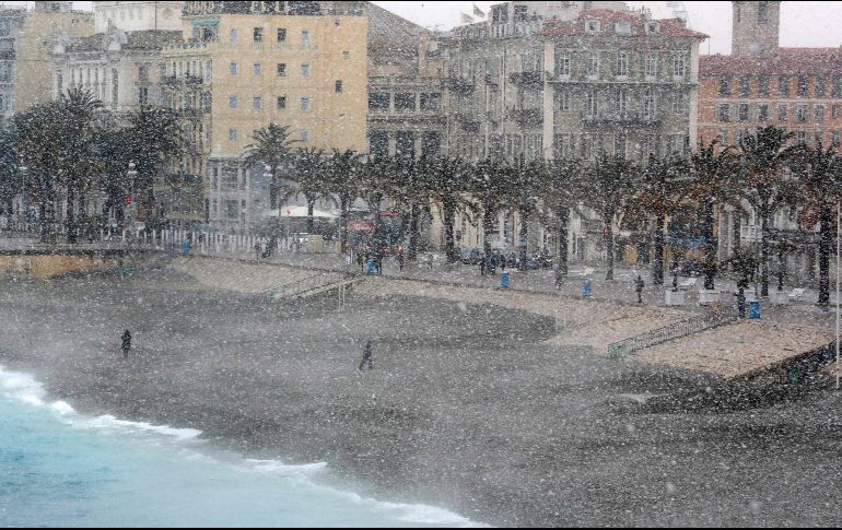 En Francia, las temperaturas caerán a -10 grados centígrados y la sensación térmica será de -18 C en los próximos días. Personas caminan por la playa durante una nevada en Niza.