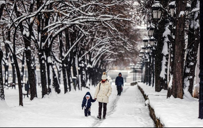 Una mujer y un niño caminan por un parque en Skopje, Macedonia.