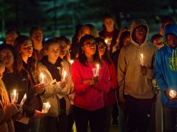 Varios alumnos de la escuela donde ocurrió la masacre encienden velas durante un homenaje a sus compañeros fallecidos. AP/H. Rousseau