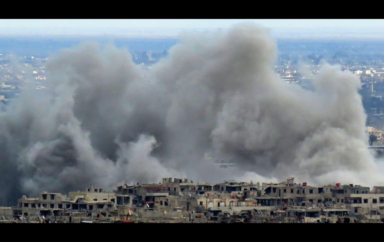 Humo se eleva hoy de un área controlada por los rebeldes sirios en Guta Oriental, durante un bombardeo. AFP